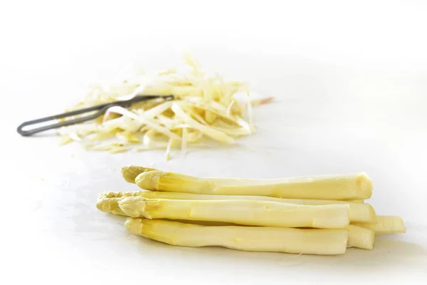 White asparagus and peel in the bright background, copy space — Stock Photo, Image