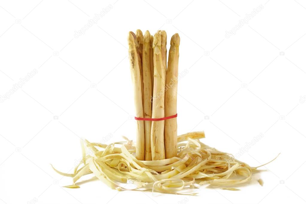 bunch of white asparagus standing in asparagus peel, isolated on white