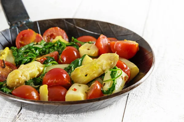 Vegetabiliska pan med stekt sparris, tomater och spinarch på en vit träbord, låg carb måltid — Stockfoto