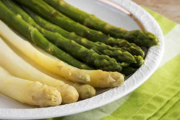 cooked asparagus, green and white on a plate, close up