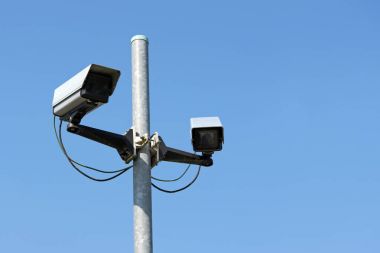 İki cctv güvenlik kameraları açık mavi gökyüzü, Emanet için kavram karşı caddede pilon ve vandalizm, suç veya terörizme karşı güvenlik