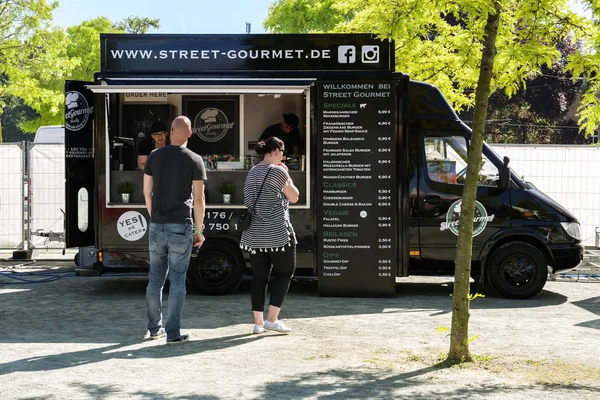 स्क्वेअरिन, जर्मनी, जून 2, 2017 : आंतरराष्ट्रीय रस्त्यावर अन्न महोत्सव दरम्यान गॉरमेट बर्गर विक्री ब्लॅक फूड ट्रकमध्ये मोबाइल स्वयंपाकघर — स्टॉक फोटो, इमेज