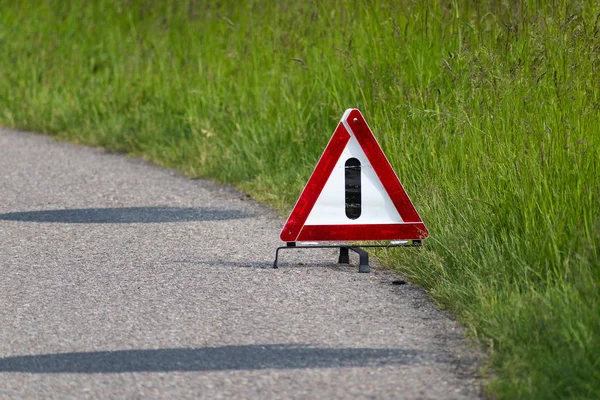 Sinal de paragem de emergência do triângulo vermelho, aviso de um carro envolvido num acidente na estrada — Fotografia de Stock