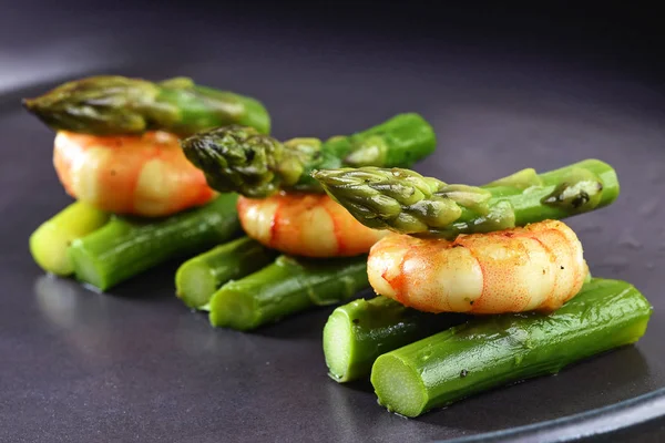 Asparagus hijau dengan udang harimau, hidangan pembuka meriah atau makanan ringan prasmanan di piring abu-abu — Stok Foto