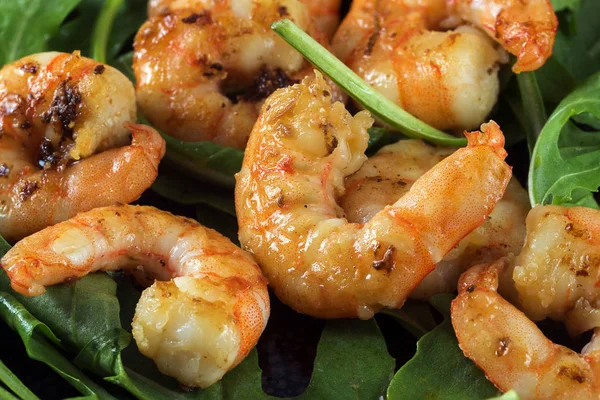 Fried prawns or shrimps on arugula rocket salad, close up shot — Stock Photo, Image