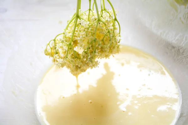 Sumergiendo flor de saúco en la masa de panqueque para un postre frito tradicional — Foto de Stock