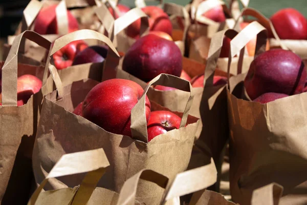 Färska röda äpplen i papperspåsar på lokalen utanför jordbrukarna marknaden en solig dag — Stockfoto