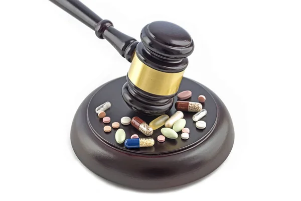 Martelletto di legge e varie droghe, compresse e pillole isolate su sfondo bianco, concetto di giustizia e medicina — Foto Stock