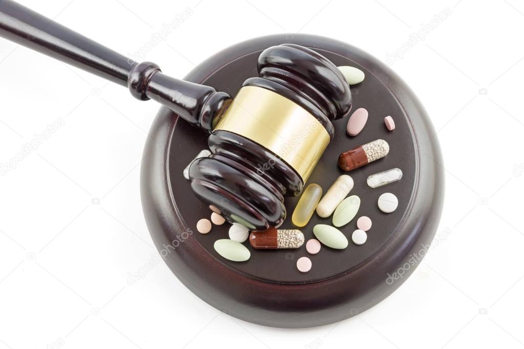 Law gavel and drugs, tablets and pills top view from above, isolated on a white background