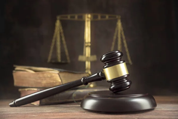 Judge gavel, old books and scales on a wooden table, justice symbols for balance and power in law and court, dark background with copy space — Stock Photo, Image