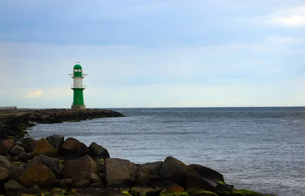 Faro rosso su pietre in mare in caso di maltempo contro un cielo grigio, Warnemuende al Mar Baltico, una destinazione turistica popolare in Germania, Europa — Foto Stock