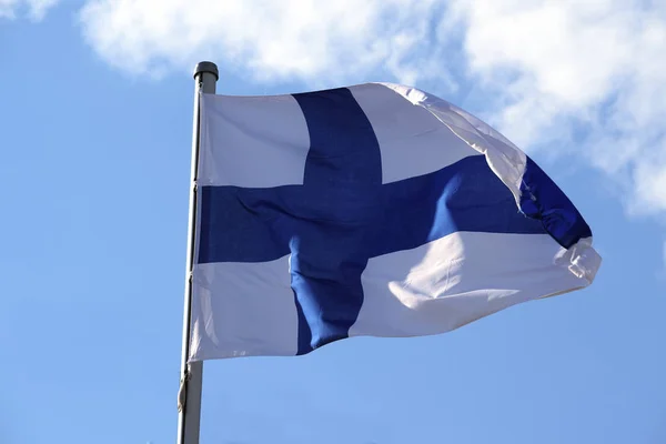 Bandera de Finlandia con una cruz azul sobre un fondo blanco sobre el cielo azul, símbolo o signo del Estado finlandés perteneciente a scandinavia y Europa — Foto de Stock