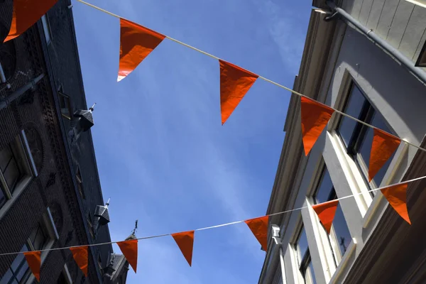 Banderas de naranja en una ciudad holandesa, decoración para apoyar al equipo de fútbol o celebrar el día de las reinas en los Países Bajos — Foto de Stock