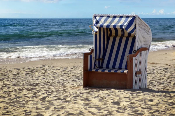 Типичная пляжная корзина кресло в песке на голубом море в солнечный день отпуска — стоковое фото