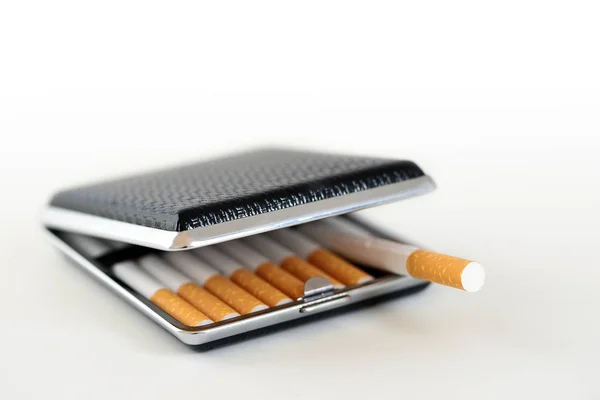 Black and silver cigarette case with tobacco filter cigarettes, background fades to white, copy space — Stock Photo, Image