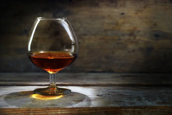 Konyak ya da sıcak rustik ahşap, keyfi veya bağımlılığı için kavram üzerinde brendi cam — Stok fotoğraf