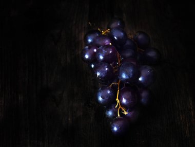 kopya alanı ile koyu kahverengi ahşap arka plan üzerinde koyu mor üzüm