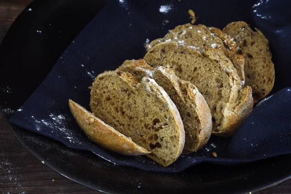 Krokante volkoren brood op een donkere achtergrond, rustieke zelfgemaakte bakken voor al gezonde levensstijl — Stockfoto