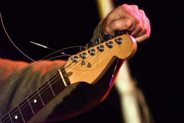 müzisyen el Sahne Alanı'nda bir elektro gitar tuning