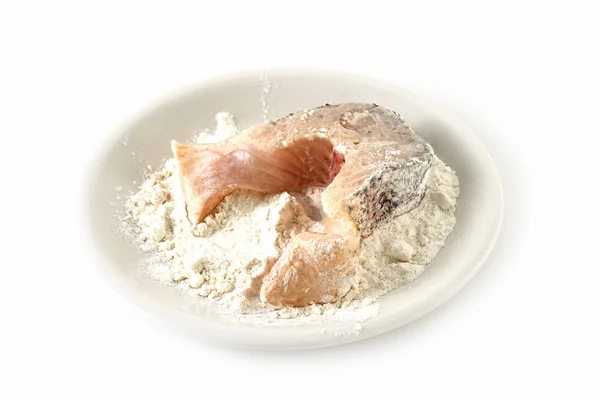 Preparing northern pike steak, fresh raw fish piece in a plate with flour, isolated on a white background — Stock Photo, Image