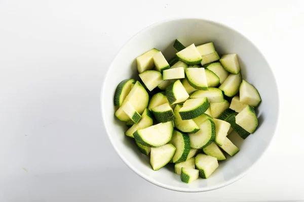 Plastry cukinii, przygotowane warzywa w misce biały na jasnoszarym tle, kopiować miejsca — Zdjęcie stockowe