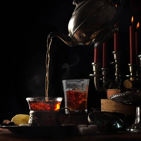 Pouring hot steaming tea from a vintage teapot into  glass cups — Stock Photo, Image