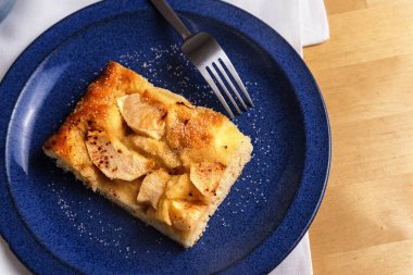 bir mavi plaka üzerinde parlak bir ahşap masa, yukarıdan, kopya alanı havai görünümü taze pişmiş elma kek