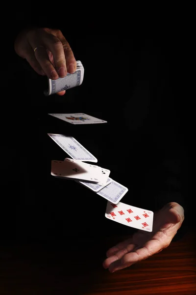 Lanciare carte da una mano all'altra su uno sfondo nero con spazio di copia, metafora aziendale o concetto per un nuovo inizio, destino e gioco d'azzardo, spazio di copia — Foto Stock