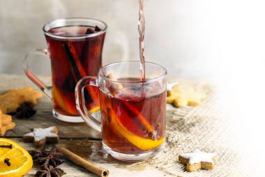 cam bardağı Noel kurabiyeleri ve portakal dilimleri, karanfil, yıldız anason gibi baharatlar ile mulled şarap ve tarçın parlak bir rustik tablo, arka plan beyaz, kopya alanı siliniyor