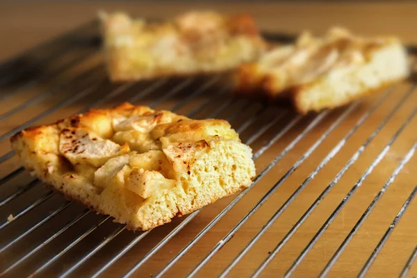Bitar av hemlagad äppelkaka på en bakning rutnät över ett träbord, kopia utrymme — Stockfoto