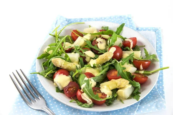 Gemischter Salat aus weißem Spargel, Cocktailtomaten und Rucola, Vorspeise-Snack auf blauer Serviette, weißer Hintergrund, Kopierraum — Stockfoto