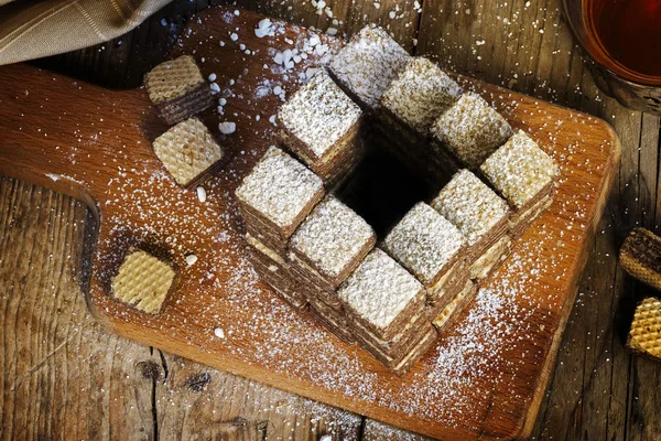 Biscuits à la gaufre construits à un escalier impossible penrose, qui monte toujours, métaphore de régime pour manger de plus en plus de bonbons, fond en bois rustique — Photo