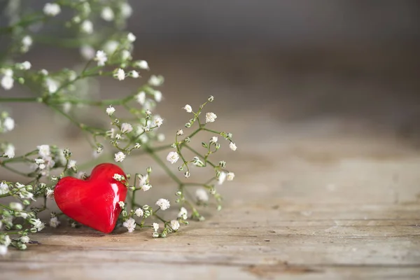 Pequeno coração vermelho de vidro e flores brancas em um fundo rústico de madeira com espaço de cópia generosa, conceito de amor para o Natal, dia da mãe e dia dos namorados , — Fotografia de Stock