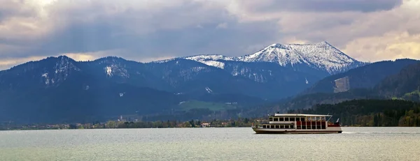 Barco de excursión en el lago tegernsee con montañas azules y cubiertas de nieve en el fondo, vista panorámica del famoso complejo turístico en los Alpes bávaros, Baviera, Alemania, Europa — Foto de Stock