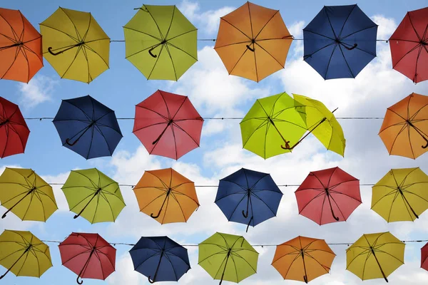 Kleurrijke paraplu's in de lucht hangen, twee zijn flirten, straat decoratie achtergrond — Stockfoto