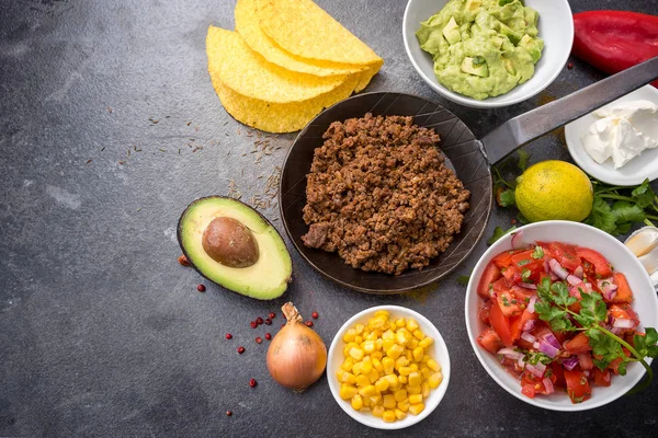 Taco sült marhahús, paradicsom, kukorica és guacamole, a sötét kő háttér másol helyet, felülnézet, a fenti hozzávalókat a töltés — Stock Fotó