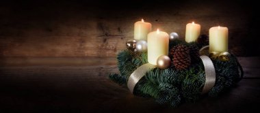 Advent çelenk dört beyaz yanan mumlar ve rustik koyu ahşap, panorama biçimine kopya alanı ile Noel dekorasyonu ile