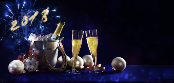 New year celebration background banner with text 2018, champagne bottle and glasses, christmas decorations and fireworks against a dark blue background in panoramic format, copy space — Stock Photo, Image