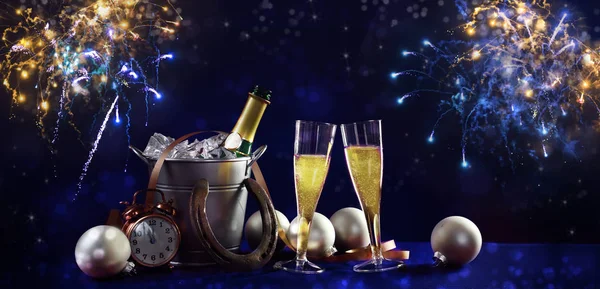New year background banner with champagne bottle and glasses,  christmas decorations and fireworks against a dark blue background in panoramic format — Stock Photo, Image