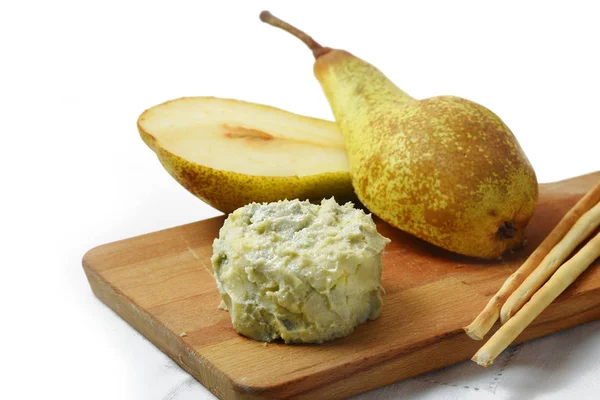 Creamy blue stilton cheese, pears and cracker sticks on a cutting board, corner background fades to white, copy space — Stock Photo, Image
