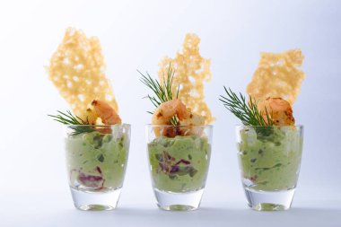 guacamole avokado kaplan ile krem karides veya karides ve gevrek peynir kraker üç gözlük, meze veya parti bir ışık gri arka plan üzerinde snack