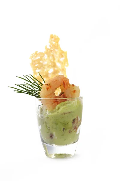 Aperitivo en un vaso, crema de aguacate con gambas tigre, parmesano crujiente y guarnición de eneldo para una fiesta festiva buffet aislado sobre un fondo blanco — Foto de Stock