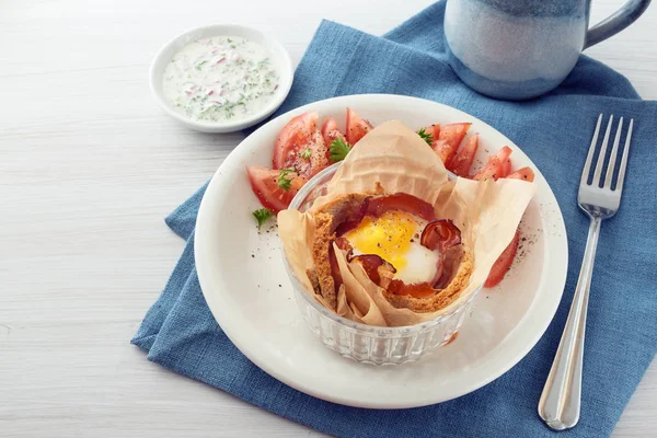Πρωινό τηγανίτα με αυγό και μπέικον με φρυγανισμένο ψωμί, ντομάτα, ντιπ με τυρί και ένα πιρούνι σε μια μπλε πετσέτα, λευκό βαμμένο ξύλινο τραπέζι, αντίγραφο χώρου — Φωτογραφία Αρχείου