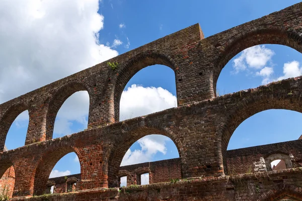 Arcos de janela no mosteiro ruína de alvenaria tijolo em Bad Doberan, norte da Alemanha, contra um céu azul com nuvens brancas — Fotografia de Stock