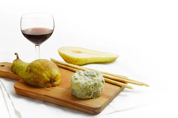 Creamy blue stilton cheese, port wine, pears and cracker sticks on a cutting board, corner background fades to white, copy space — Stock Photo, Image