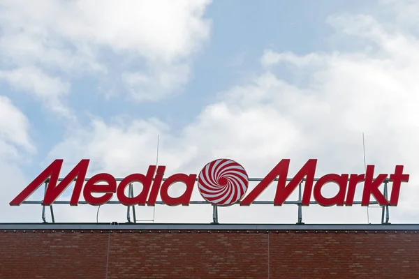 Luebeck, Germany - February 1, 2018: Media Markt logo on a building against the blue sky with clouds and copy space. Media Markt is a German chain of stores selling consumer electronics in Europe and Asia — Stock Photo, Image