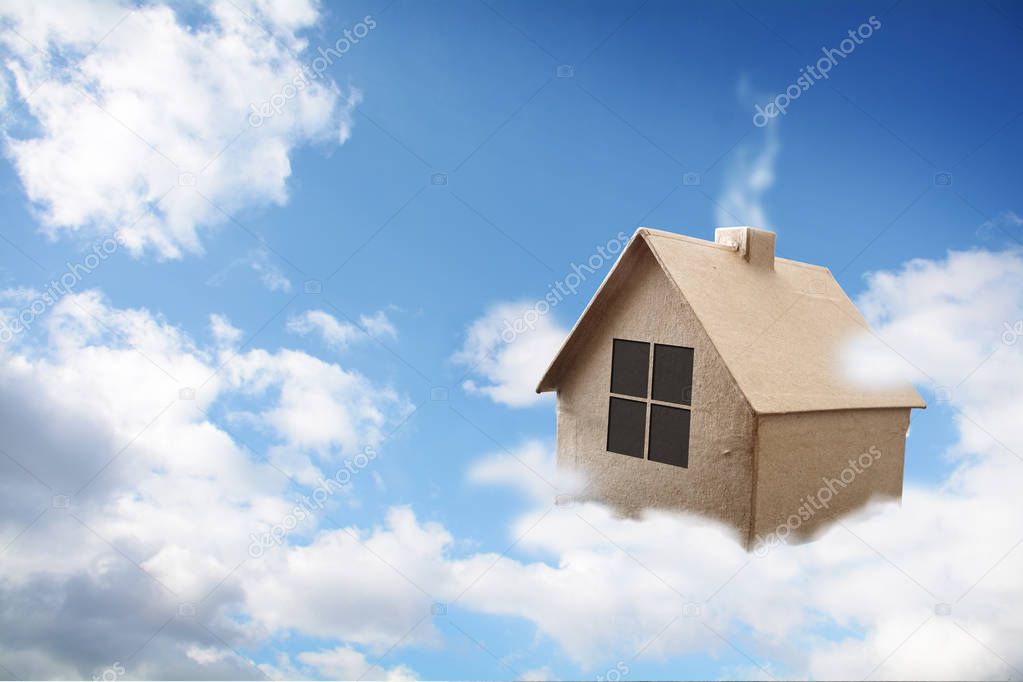 House made of brown cardboard is flying on the clouds in the  blue sky, dream of a own home, real estate concept with copy space