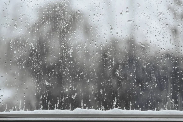 Gouttes de neige et de pluie sur une fenêtre, fond de mauvais temps avec espace de copie — Photo