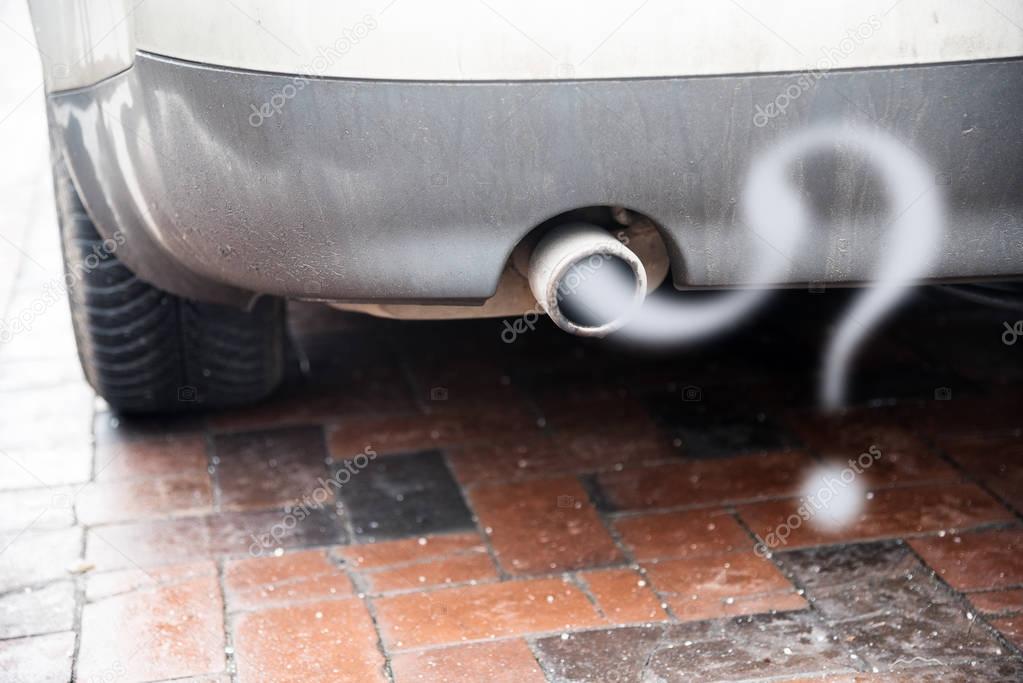 Exhaust from a car with diesel engine emitting gas in the shape of a question mark, concept for the problem of reducing the particulate matter load without driving ban