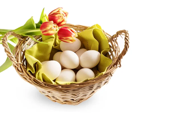 Basket with fresh chicken eggs and red tulips for a Happy Easter breakfast, isolated on a white background, copy space — Stock Photo, Image